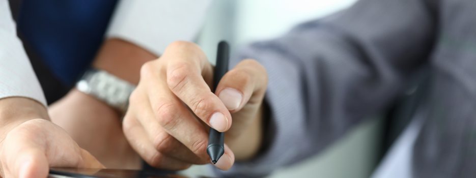 man holds stylus puts signature tablet