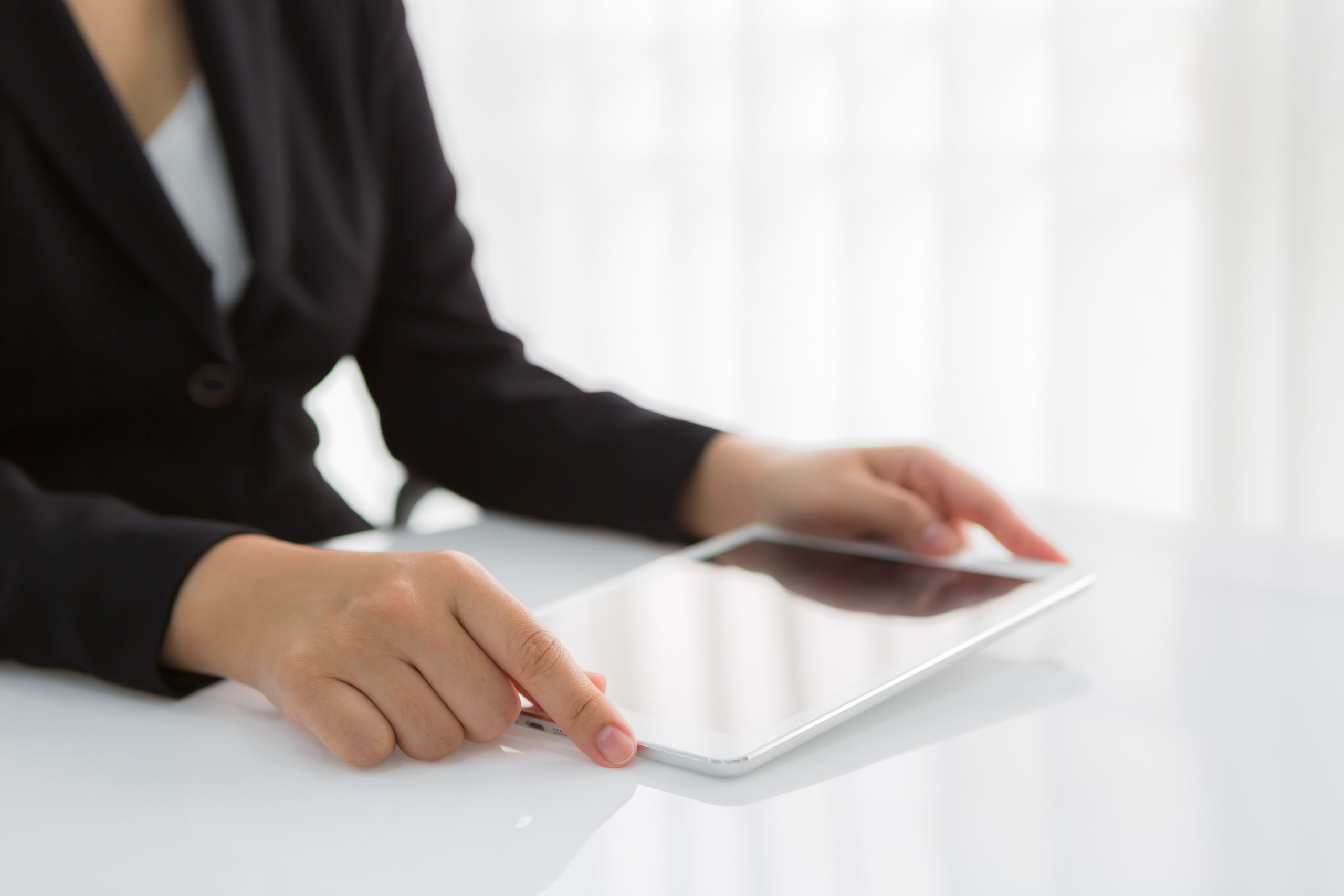 Woman hand touch white tablet with blank empty screen