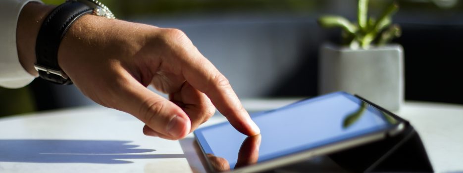 Man hand clicks on digital tablet, closeup